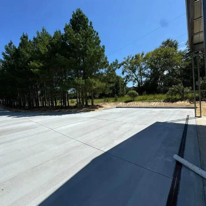 Large smooth broom-finished concrete slab beside a metal building