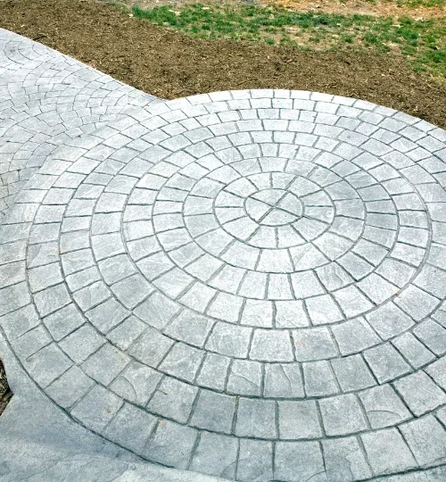 Circular stamped concrete patio with a radial cobblestone pattern