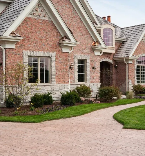 Decorative stamped concrete driveway and walkway at a brick house