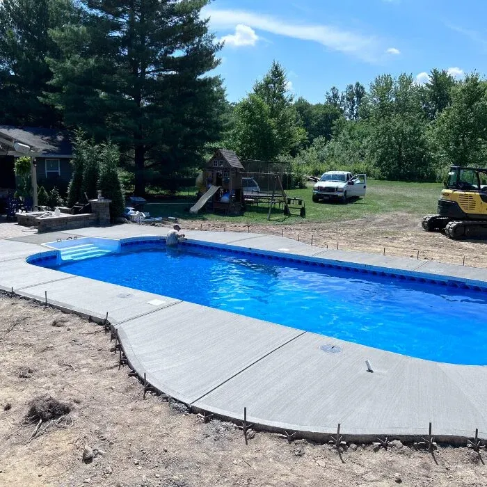 Broad concrete pool deck surrounding a rectangular in-ground pool